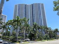 an apartment building with palm trees in front of it