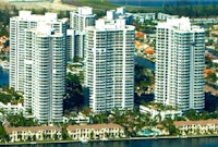 an aerial view of a group of high rise buildings near a body of water