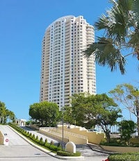 a tall building with palm trees in front of it