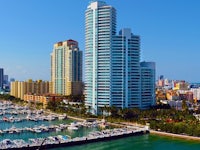 a marina with boats docked in front of tall buildings