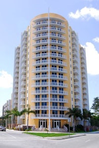 an apartment building with balconies and palm trees