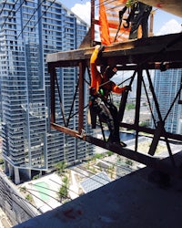 a man is working on a crane in a city