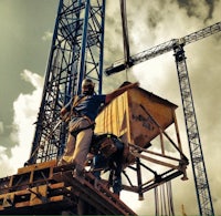 a man is standing on top of a crane