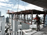 a construction worker is working on a crane in a city