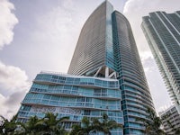 a tall building with palm trees in front of it